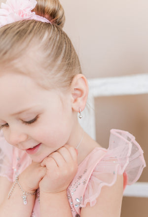 toddler wearing Huggie Hoop Heart Sterling Silver Earrings